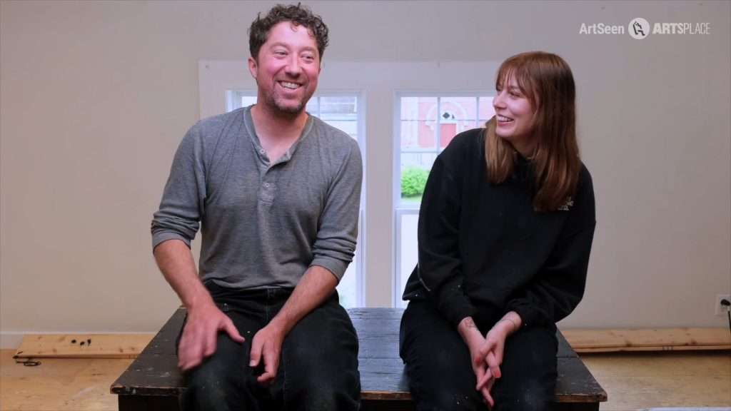 Leah McInnis and David Peters seated facing camera and laughing