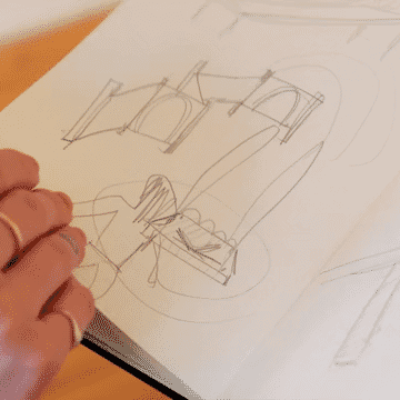 Short loop of artist's hand turning pages of a sketchbook